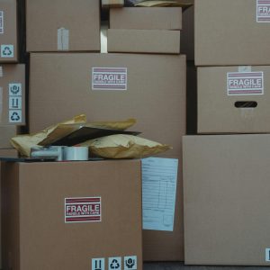 A variety of cardboard boxes labeled 'fragile' stacked in a vehicle for shipping or storage.